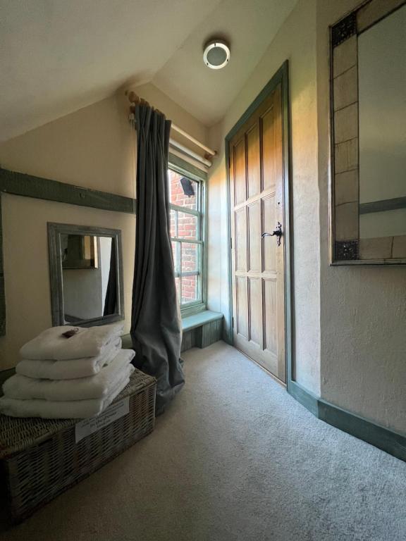 a room with a mirror and a door and towels at The Tea House in Rye