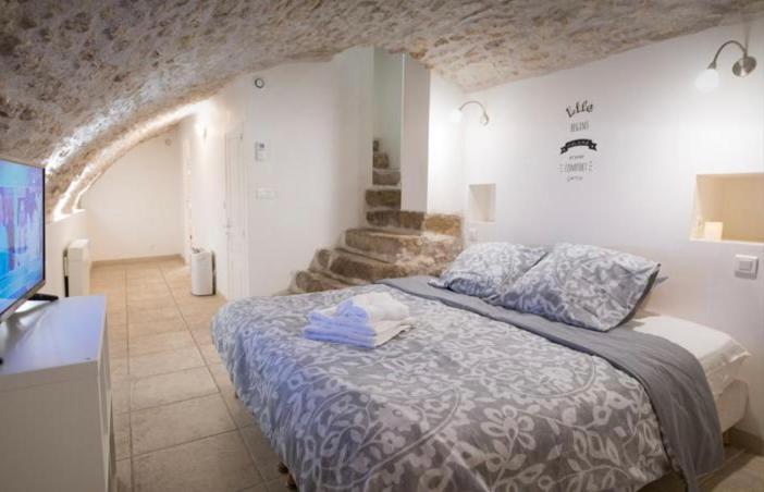 a bedroom with a bed and a stone wall at LE BON'APPART proche INSEAD in Fontainebleau