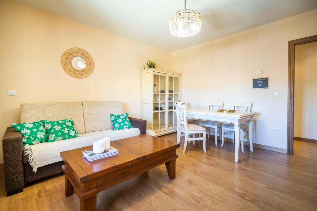 een woonkamer met een bank en een tafel bij Apartamentos Ribera del Duero Las Escuelas in Vadocondes