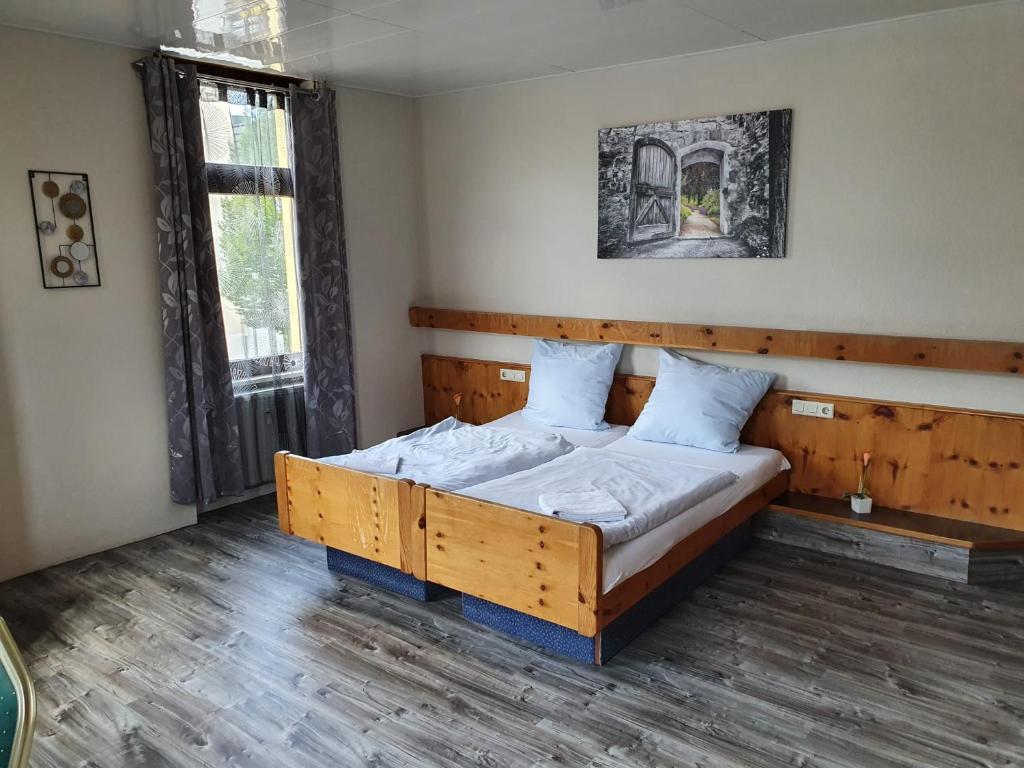 ein Schlafzimmer mit einem Holzbett in einem Zimmer in der Unterkunft Stay2Night Hotel in Dillingen an der Saar
