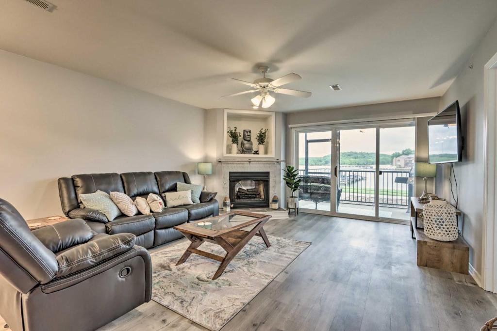 a living room with a leather couch and a fireplace at Camdenton Condo with Pool Access and Lake Views! in Camdenton