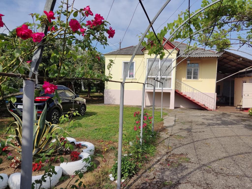 ein Haus mit einem Garten mit Blumen im Hof in der Unterkunft Абхазия Дом Под Ключ Алахадзы in Alakhadzi