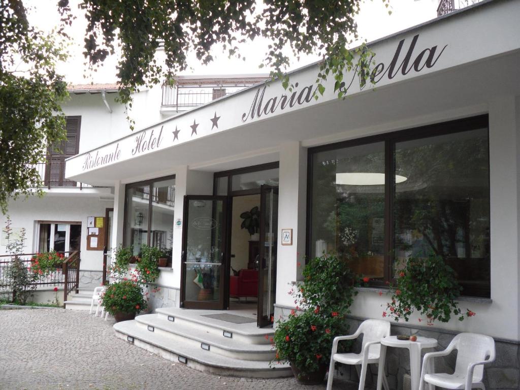 a white building with a sign on the front of it at Hotel Maria Nella in Bardineto