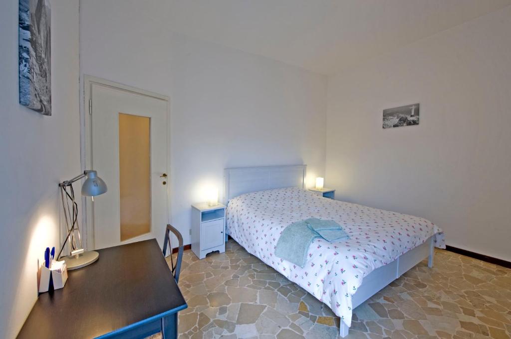 ミラノにあるApartment Chiesarossaのベッドルーム1室(ベッド1台、デスク、2つの照明付)