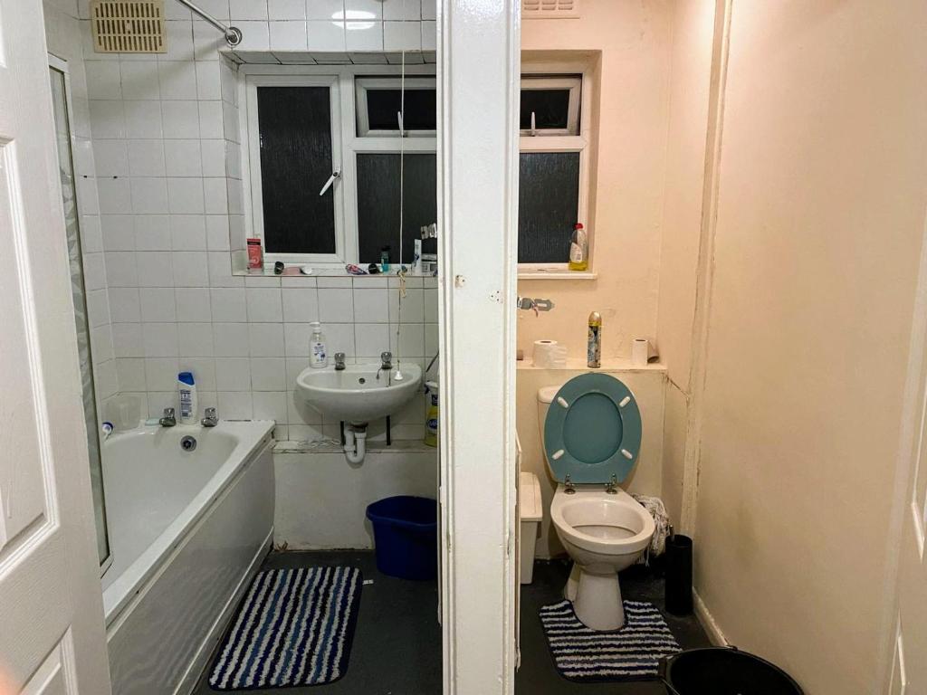 a bathroom with a toilet and a tub and a sink at London Double Room with free parking and wifi in Hornchurch