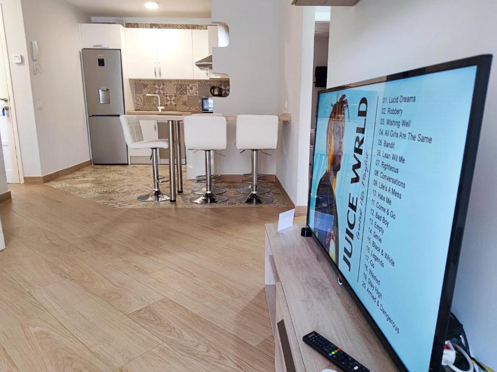 a living room with a tv and a kitchen at Playa de las Americas 600mt from the beach internet free in Playa de las Americas