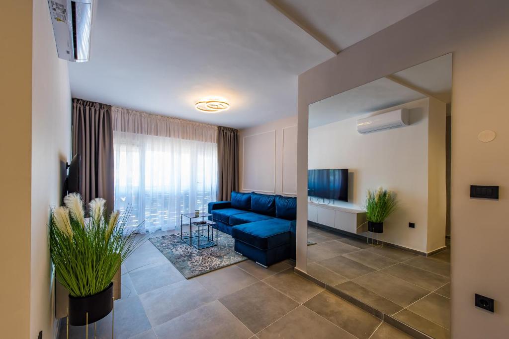 een woonkamer met een blauwe bank en een tafel bij AniMa Apartment in Zadar