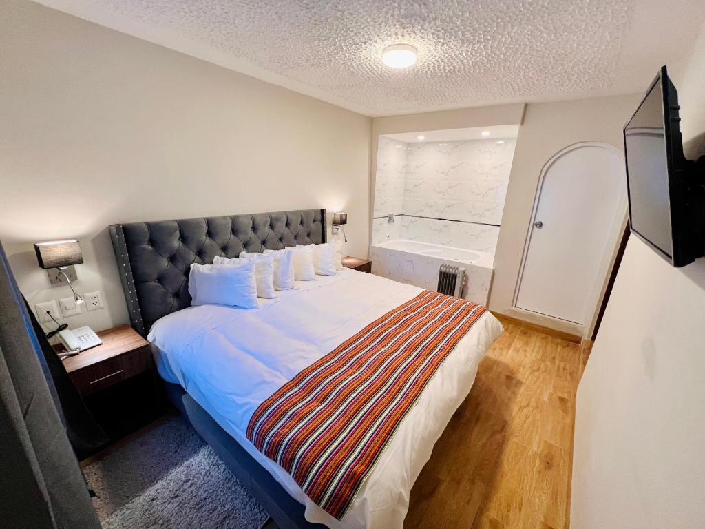 een slaapkamer met een groot bed met een groot raam bij Casona Plaza Hotel Cusco in Cuzco