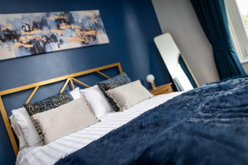 a blue bedroom with a bed with pillows at * POPULAR * Stunning quiet apartment by the sea in Torquay