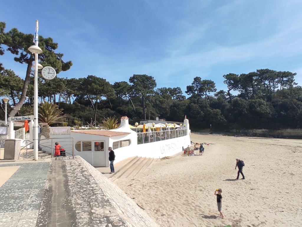 - un groupe de personnes sur une plage avec un bateau dans l'établissement A l'abordage, appartement 2 pièces plage de Nauzan, à Vaux-sur-Mer