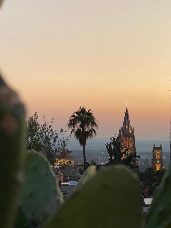 a view of a city at sunset with a church at Hotel del Sol in San Miguel de Allende