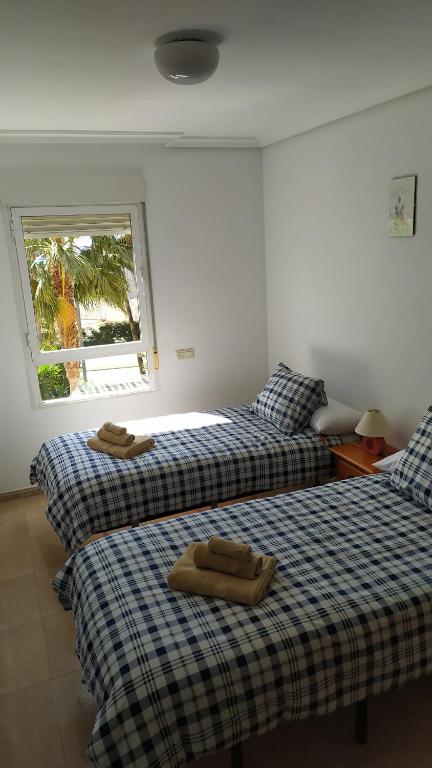 Habitación con 2 camas y toallas. en HABITACIONES EN frente DEL PUERTO, en Almería