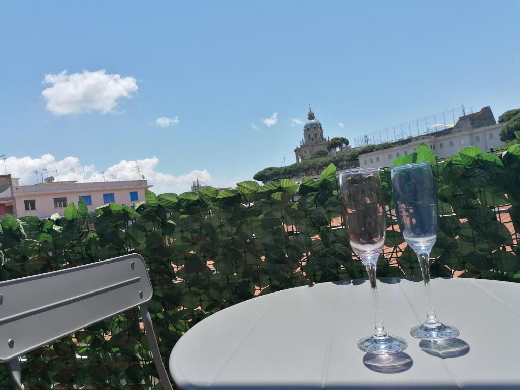 two wine glasses sitting on a table on a balcony at GIOVANNA HOME COLLECTION in Messina