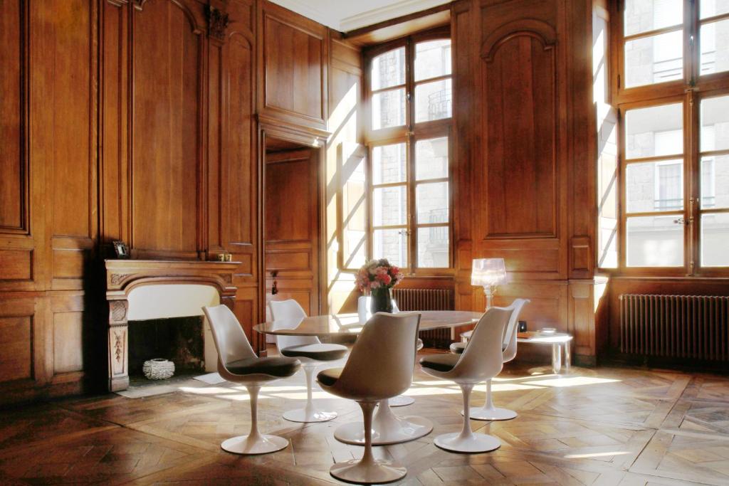 une chambre avec une table, des chaises et une cheminée dans l'établissement Apartment Le 1725, à Saint-Malo