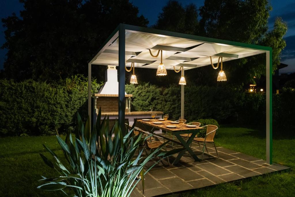 a picnic table under a white canopy in a garden at night at Palamoutaki Villa in Koskinou