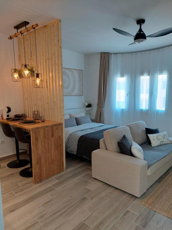 1 dormitorio con cama, sofá y escritorio en Arena Negra en Tarajalejo