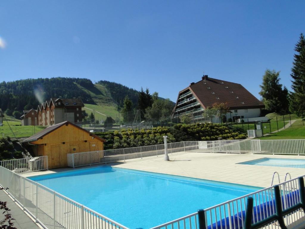 une grande piscine bleue à côté d'un bâtiment dans l'établissement Détente au Cœur de la Station, à Métabief