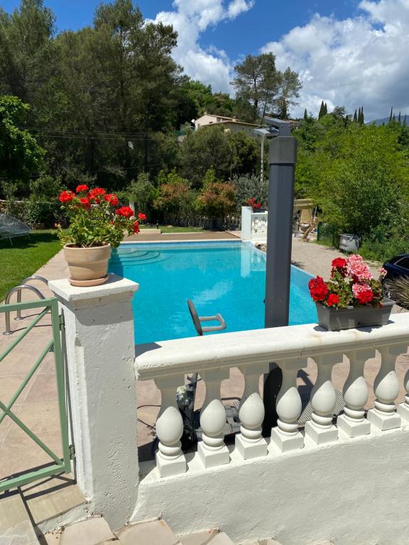 una recinzione bianca con fiori e una piscina di À partir de 420 euros la semaine Studio meublé accès piscine libre a Grasse