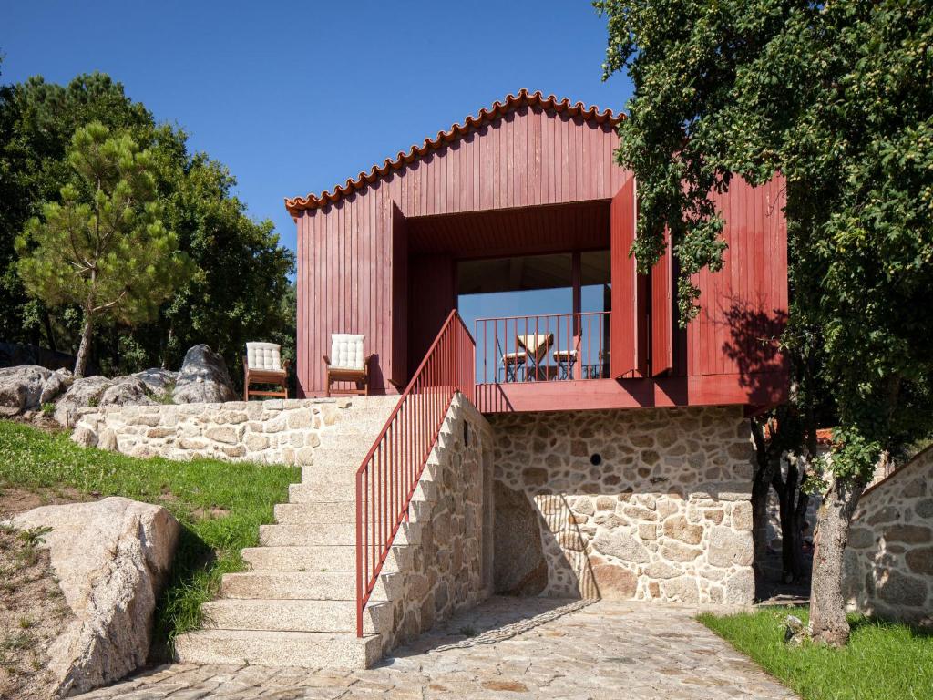 een rood huis met een trap en een balkon bij Traços D'Outrora in Vale de Cambra