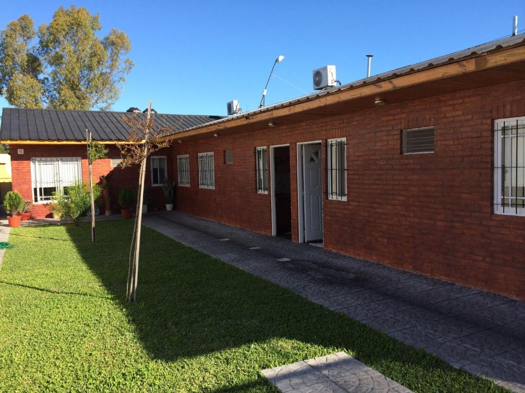 un edificio de ladrillo rojo con un pequeño árbol en el patio en Ciudad de las Colinas en Victoria