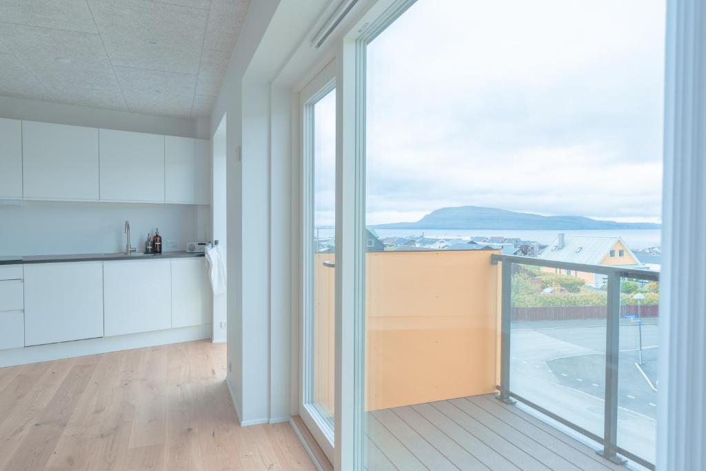 a kitchen with a large window and a view of the ocean at New / Stunning Sea View / Light / 3 BR in Tórshavn