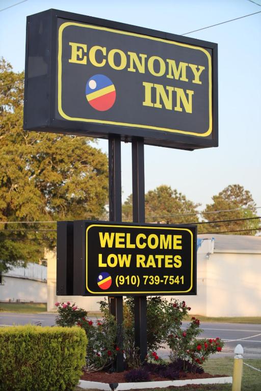 a welcome sign for a low rates store at Economy Inn in Lumberton
