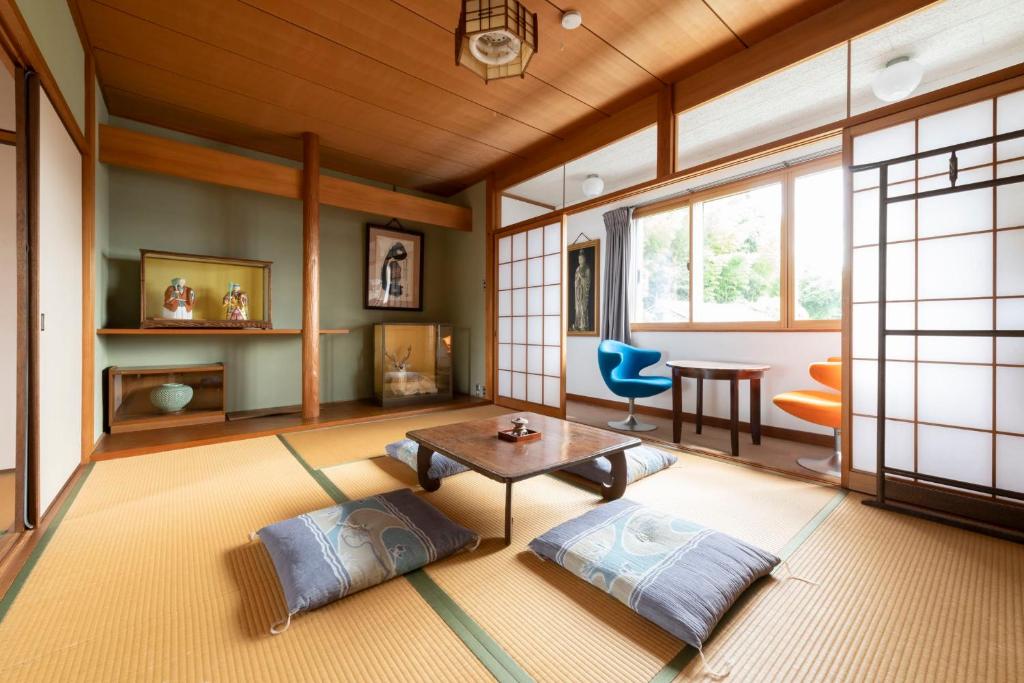 a living room with a table and two pillows at Niwamori_org in Nara