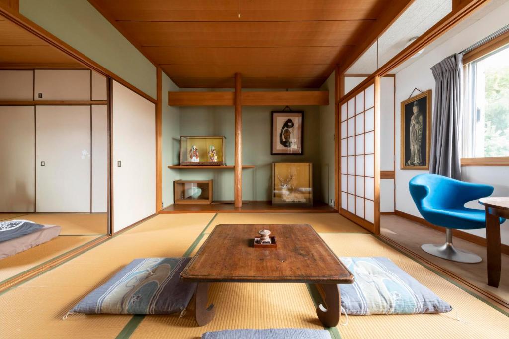 un soggiorno con tavolo e sedia blu di Niwamori_org a Nara