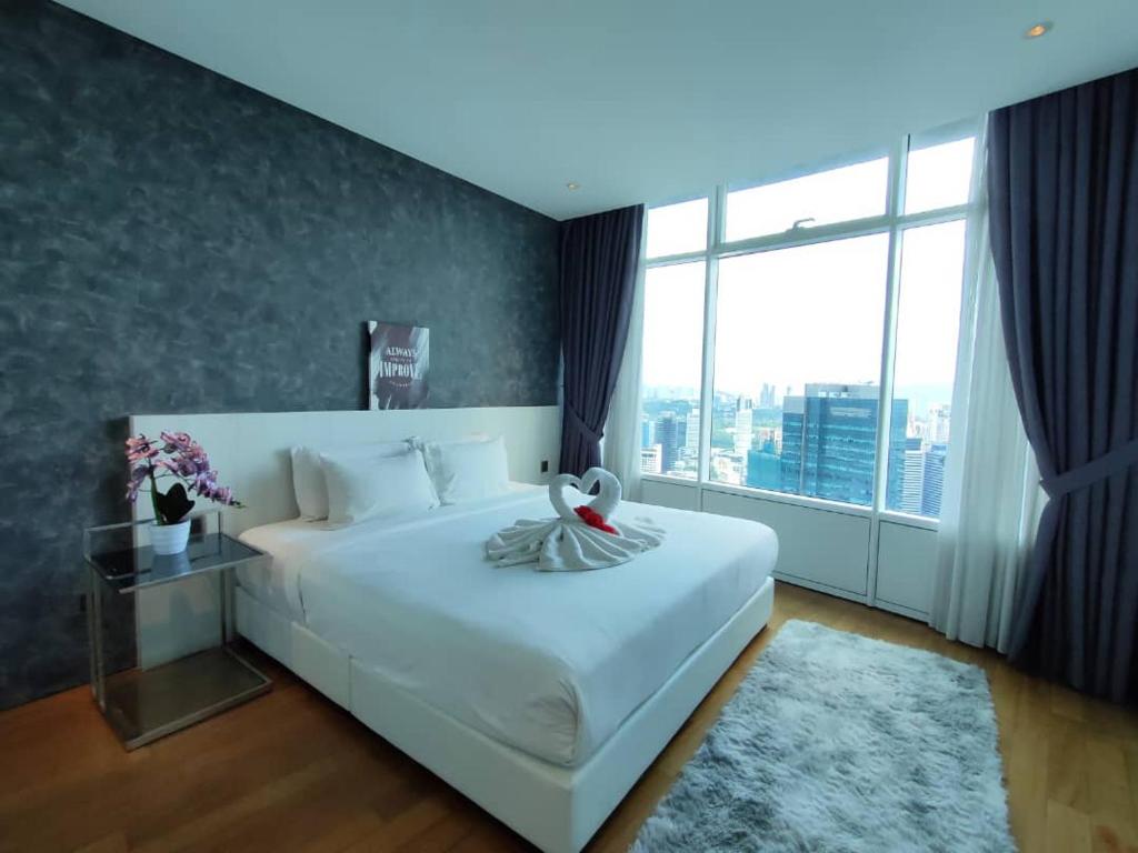 een slaapkamer met een groot wit bed en een groot raam bij Vortex Suites KLCC by Guesthouse Kuala Lumpur in Kuala Lumpur