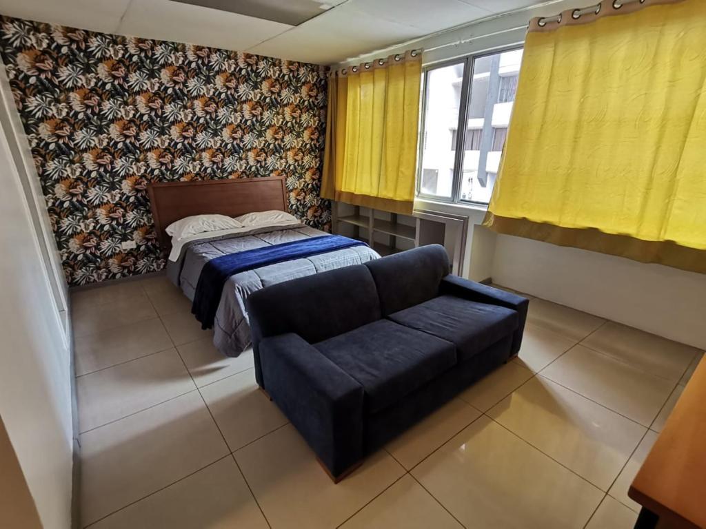 1 dormitorio con 1 cama y 1 sofá en Hermoso Loft, en Quito