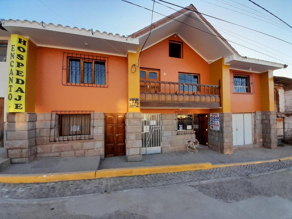 Casa de color naranja con balcón en una calle en Hospedaje Encanto de Chinchero en Chincheros