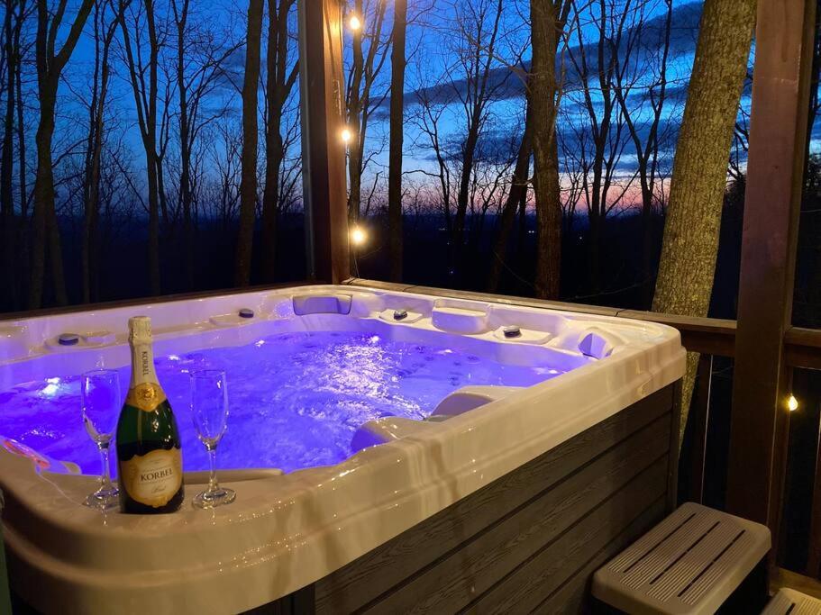 a hot tub with a bottle of wine in it at MTN Cabin Sleeps 10 - 5 Mins To Fishing & Camping in Ellijay