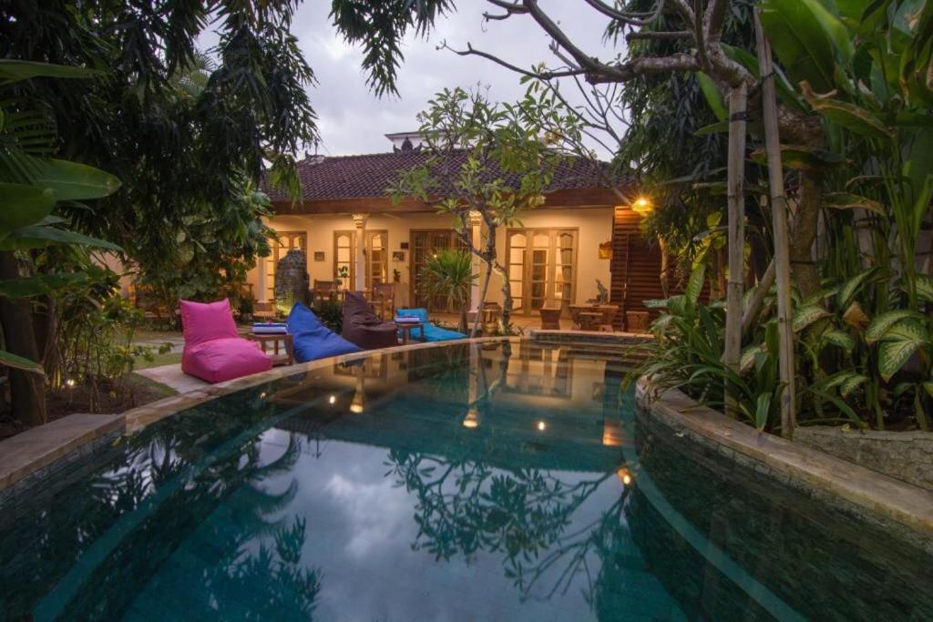 a swimming pool in front of a house at Bale Seminyak in Seminyak