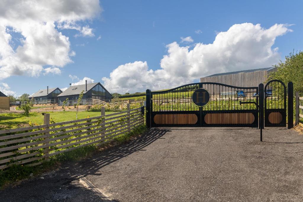 a black gate with a fence and a field at Eagles Peak in Allerston