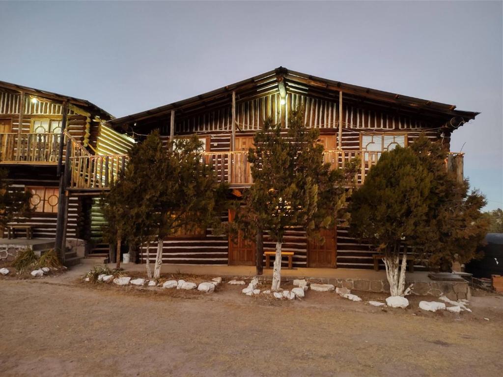 una gran casa de madera con árboles delante de ella en Room in Cabin - Parador Arewa La Energia Que Impulsa El Alma, en Creel