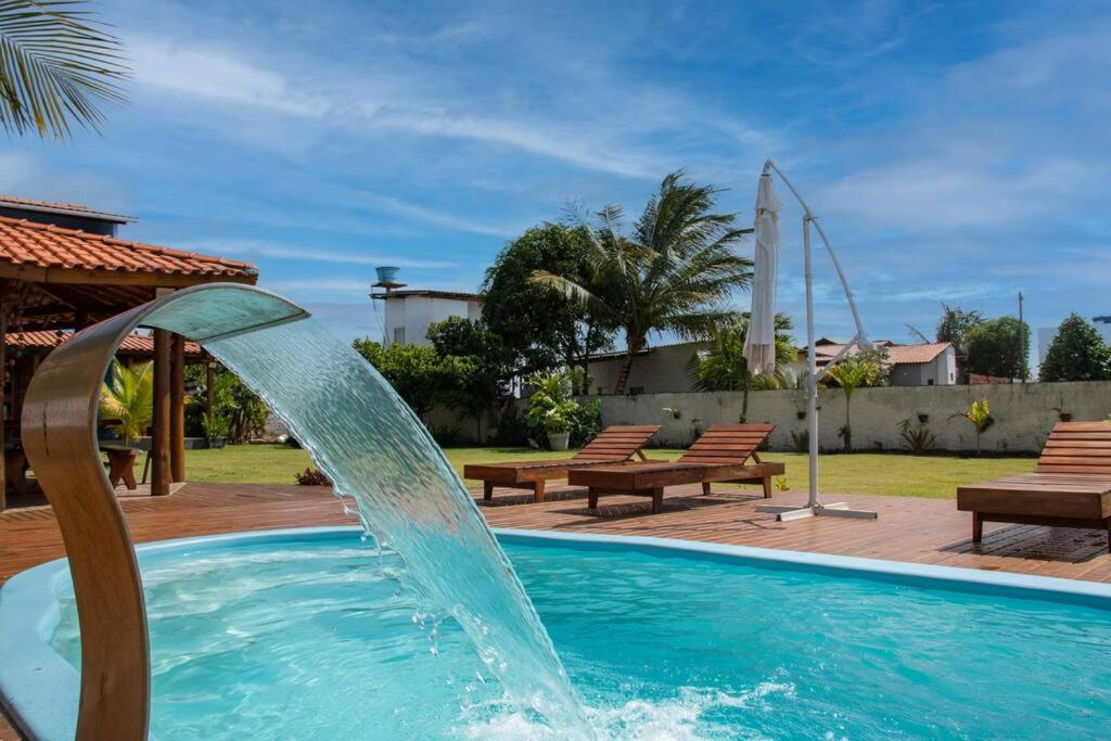 a pool with a water fountain in a yard at Recanto Ancora Azul - Taipu de Fora in Barra Grande