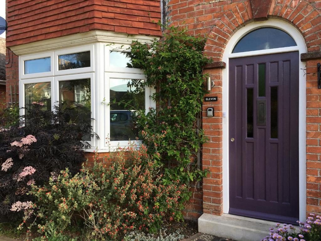 a brick house with a purple door and a window at 11 Beech Road in Weymouth