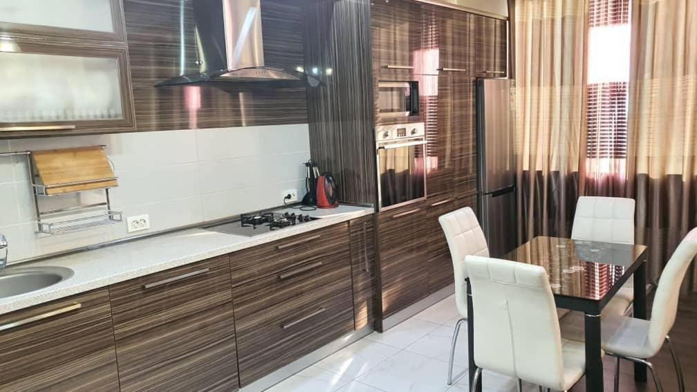 cocina con fregadero y mesa con sillas en Apartment studio with good view, en Bishkek