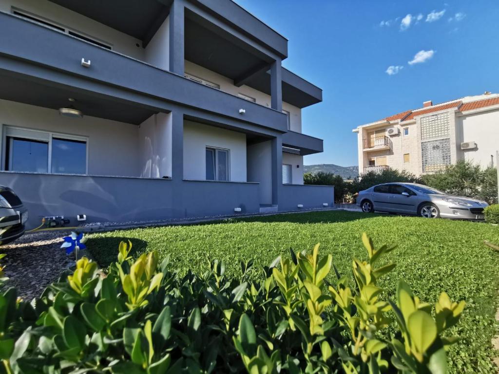 a house with a car parked in front of it at Studio apartman Gili in Kaštela