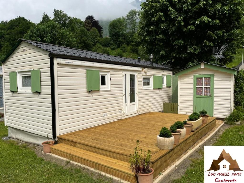 une maison avec une terrasse en bois dans une cour dans l'établissement Bungalow de 2 chambres avec jardin amenage et wifi a Cauterets, à Cauterets