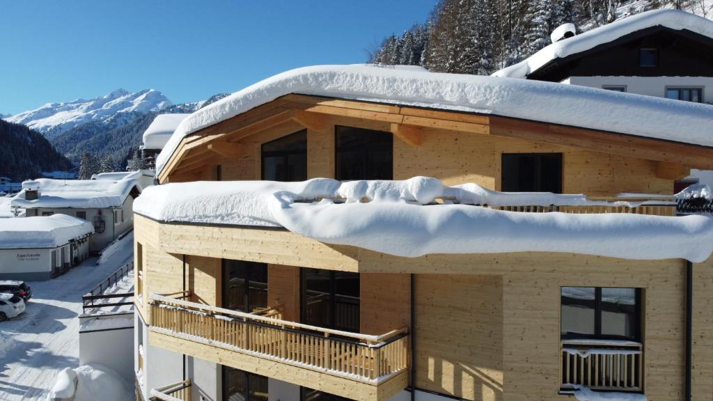 un techo cubierto de nieve de un edificio con nieve en ARLhome - Zuhause am Arlberg en Sankt Anton am Arlberg