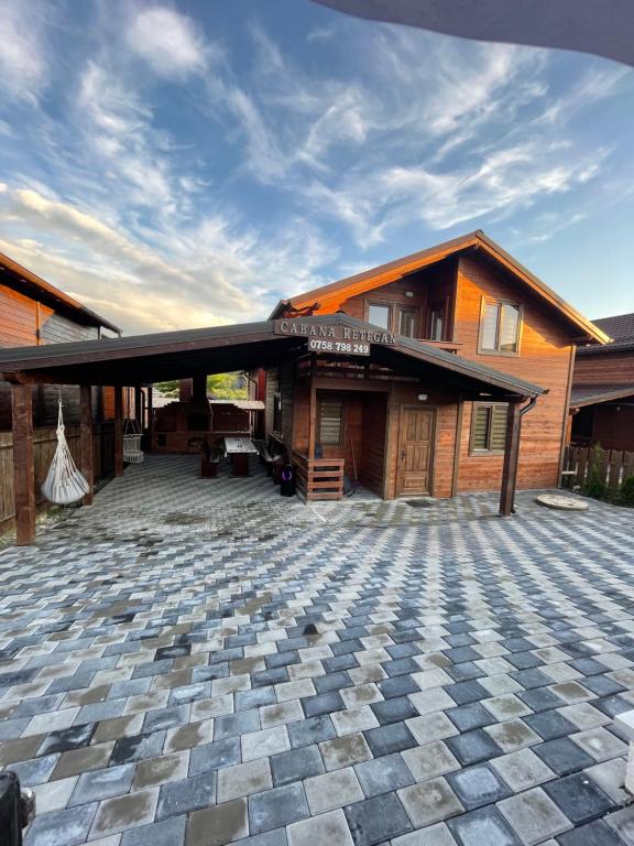 a building with a stone patio in front of it at Cabana Retegan Băile Figa in Beclean