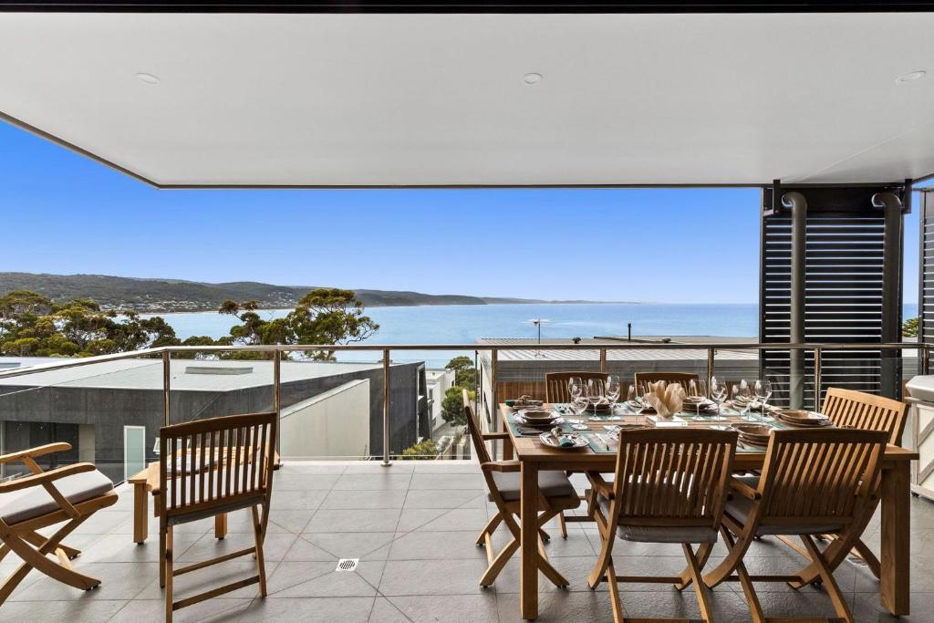 a dining table on a balcony with a view of the ocean at Oceania 11 in Lorne