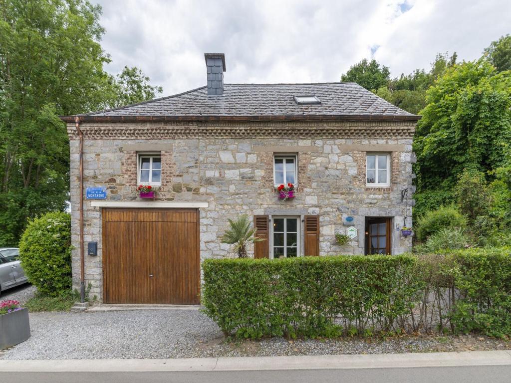 an old stone house with a wooden garage at Charming Cottage in Anseremme with Fenced Garden in Dinant