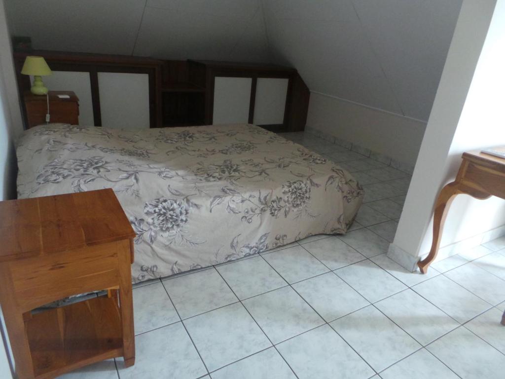 a small bedroom with a bed and a wooden table at Entre cocotiers et Filaos in La Saline les Bains