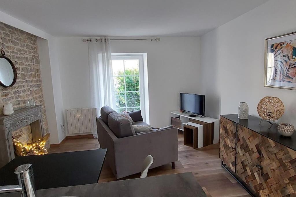 uma sala de estar com um sofá e uma lareira em Gîte chez Marianne- la halte Jurassienne em Montmorot