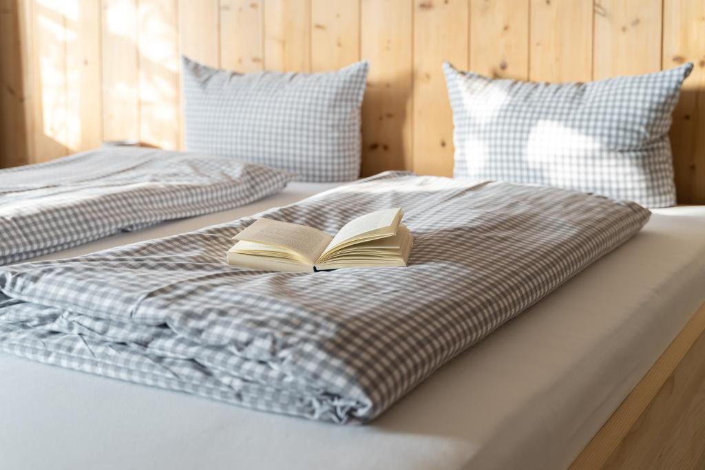 two beds with a book on top of it at Alps Hostel in Pfronten