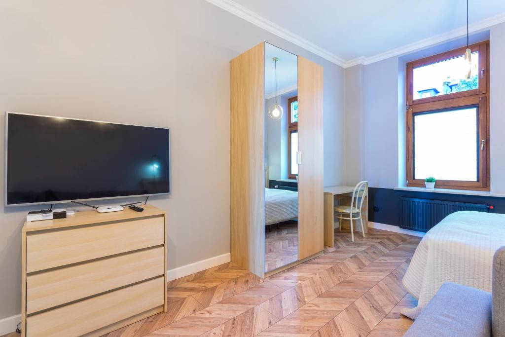 Televízia a/alebo spoločenská miestnosť v ubytovaní Apartamenty Łazarza 17