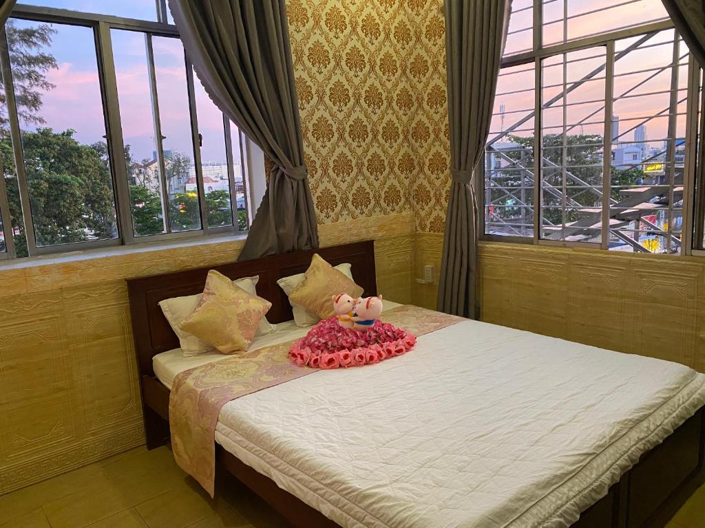 ein Schlafzimmer mit einem Bett mit einem gefüllten Schwein drauf in der Unterkunft ĐÔNG NAM HOTEL CẦN THƠ in Cần Thơ