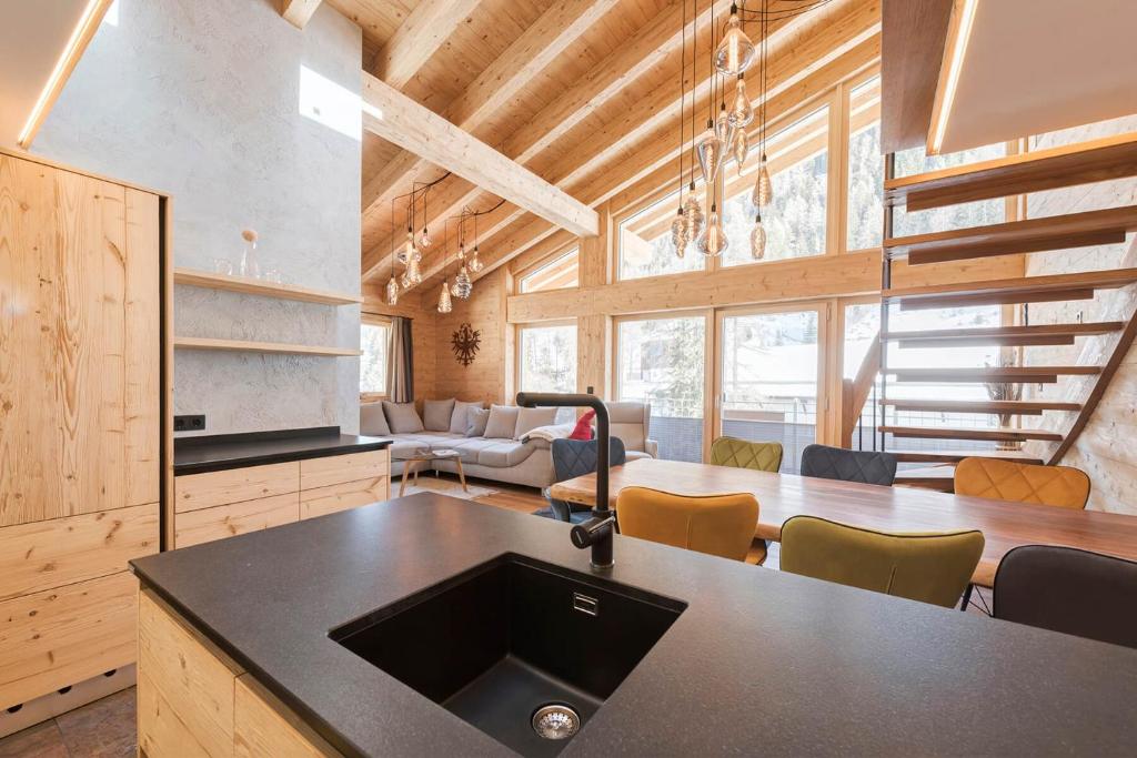 a kitchen and living room with a table and chairs at Quality Hosts Arlberg - ALPtyrol Appartements in Sankt Anton am Arlberg